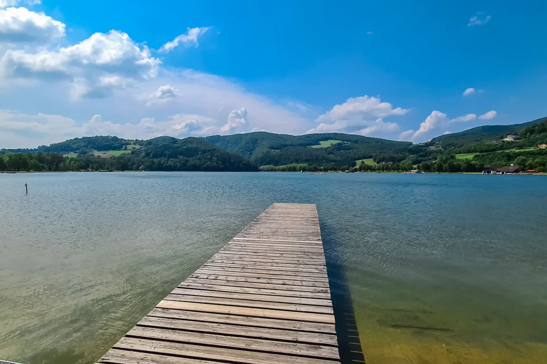 Der-Holzsteg-erstreckt-sich-in-das-ruhige-Wasser-des-Stubenbergsees